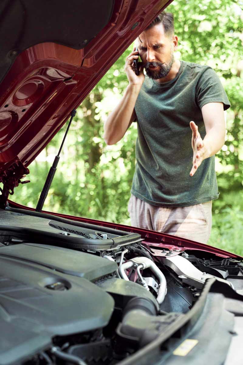 Junger Mann prüft Getriebeschaden bei Schrottauto Ankauf Stuttgart